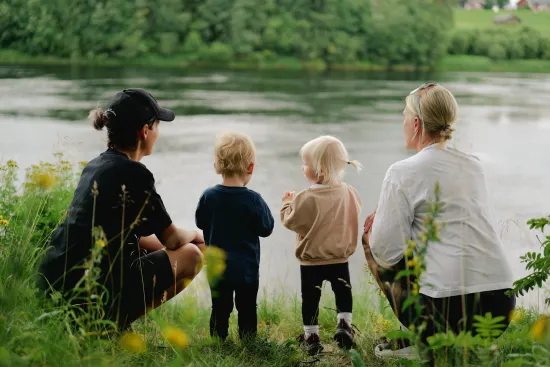 familj sittandes vid älven